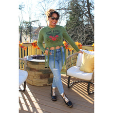 Load image into Gallery viewer, Front view of fringe tie over crop top with rock N&#39; roll design with light wash jeans and sunglasses
